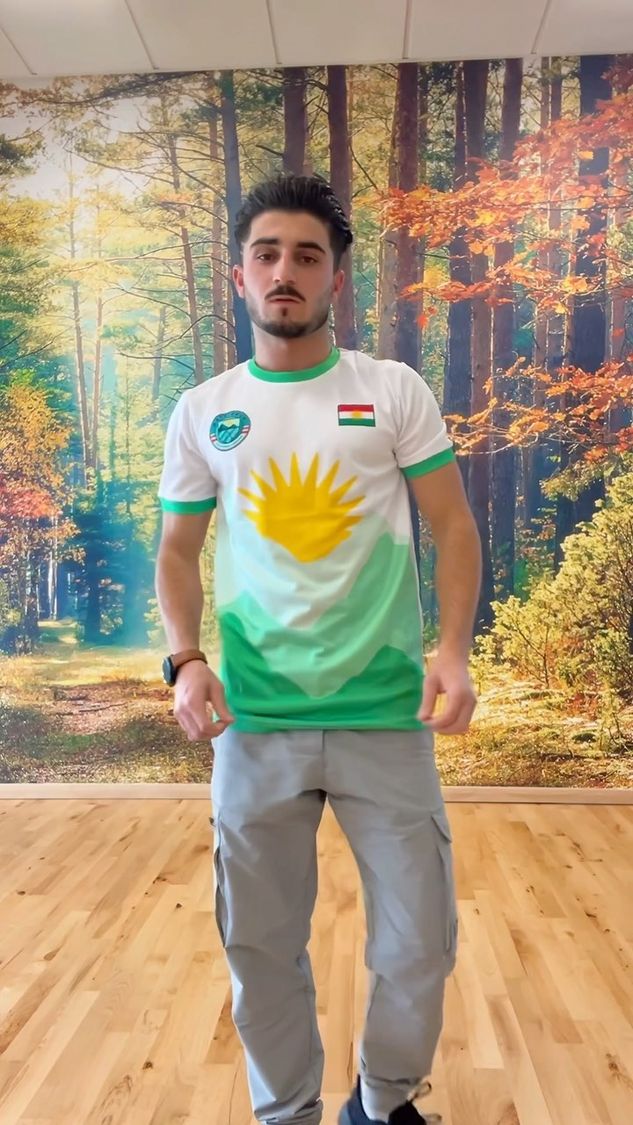 Junger kurdischer Mann mit der Flagge Kurdistans als Schal